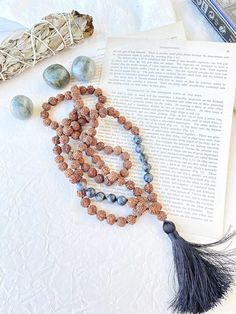 "Natural Rudraksha seeds and labradorite mala garland for meditation made by hand for me. 108 knotted bead garland for counting mantras.  With these seeds, traditionally used to pray in Hinduism and Buddhism, malas or Hindu rosary are made, which must have 108 beads (a \"magic\" number in Hinduism).  But they are also widely used in traditional Indian medicine for their supposed healing properties. In this mala we combine the mystique of rudraksha seeds with different stones that complement each other, resulting in very special jewels  I make each mala by hand, knotting each of the 108 beads with great care and I made every single silky and delicate tassel. I use a very resistant braided macrame rope, achieving a mala that lasts over time. This sacred mala necklace has 108 knotted beads of Holistic Mala With 108 Beads For Festival, Holistic Mala With 8mm Beads For Festivals, Spiritual Mala With 108 Beads For Festival, Handmade Holistic Mala For Festival, Holistic Handmade Mala For Festivals, Holistic Hand-strung Mala For Meditation, Holistic Hand-strung Healing Mala, Adjustable Holistic Mala For Meditation, Holistic Hand Knotted Jewelry For Rituals