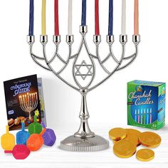 a hanukkah menorah with colorful candles and coins next to it