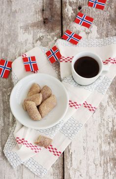 a white plate topped with cookies next to a cup of coffee on top of a table