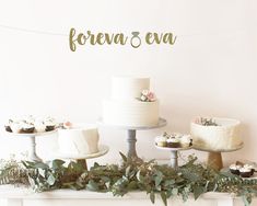 a table topped with cakes and cupcakes next to a wall