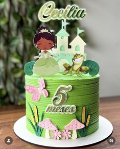 a green cake with a princess and frog on top