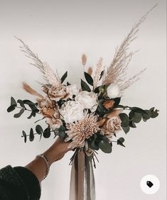 a person holding a bouquet of flowers in their hand