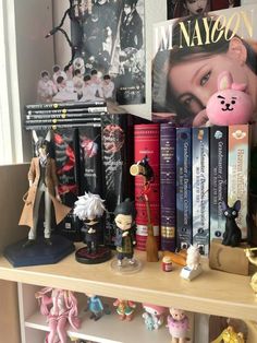 a shelf with many books and figurines on it