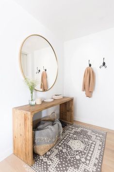 a wooden bench sitting in front of a mirror on top of a wall next to a rug