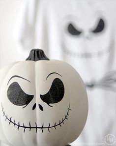 a white pumpkin with black eyes and nose painted to look like jack skellingy