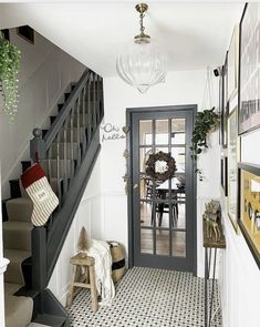 an entry way with stairs and pictures on the wall