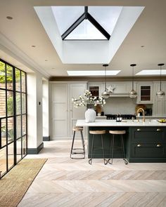 an open kitchen with skylights and green cabinets