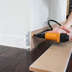 a person using a power drill to attach a piece of plywood on the floor