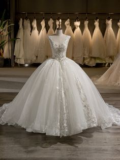 a white wedding dress on display in front of other dresses