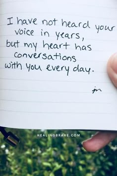 someone holding up a piece of paper that says i have not heard your voice in years, but my heart has conversations with you every day