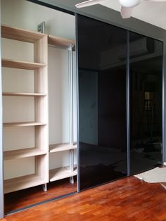 an empty room with sliding glass doors and shelves in the middle, next to a hard wood floor