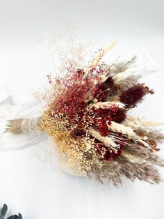 dried flowers are arranged on a white surface