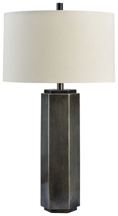 a table lamp with a white shade on it and a black square shaped object in the middle