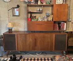 an old fashioned entertainment center with many items on the floor and in front of it