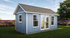 a small blue shed sitting on top of a lush green field next to pink flowers