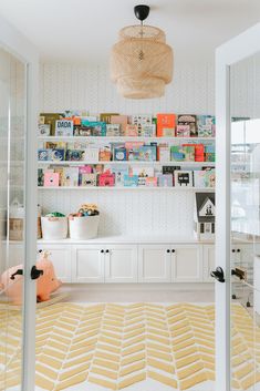 there is a room with many books on the shelves and toys in baskets hanging from the wall