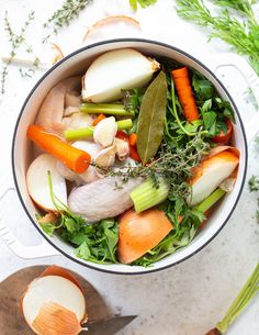 a pot full of chicken broth with carrots and celery