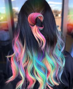 the back of a woman's head with multi - colored hair and black top