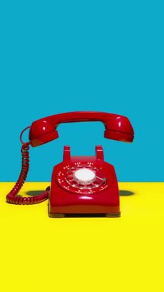 a red telephone sitting on top of a yellow table