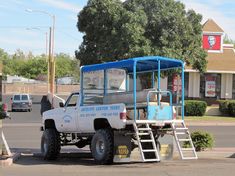 a white truck parked in front of a building with a ladder on the back of it