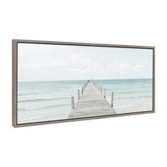 a framed photograph of a pier on the beach