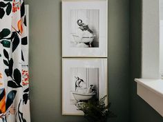 two framed pictures hang on the wall above a bathtub in a bathroom with green walls