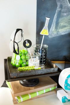 a science themed party with green and white items on a tray, including beakers