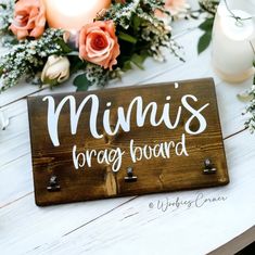 a wooden sign that says, mini's brady board on it next to flowers and candles