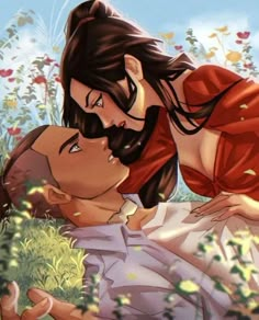 a man and woman laying on the ground in front of some flowers with their heads touching each other