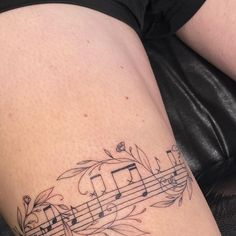 a woman's thigh with musical notes on it