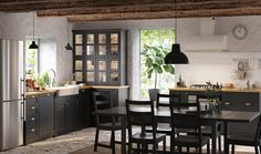 a kitchen with a table and chairs in it next to a window that has a clock on the wall