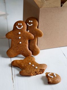 two gingerbread cookies with white sprinkles next to a cardboard box