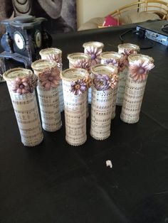 there are many vases with flowers on them sitting on the table next to each other