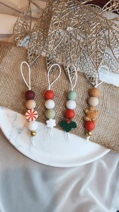 four christmas ornaments are hanging on a plate