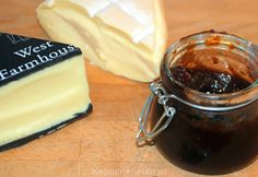 a glass jar filled with jam next to two slices of cheese