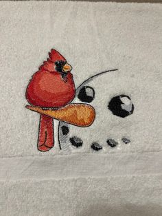 a red bird sitting on top of a white towel