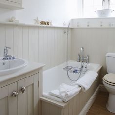 a bathroom with a tub, toilet and sink