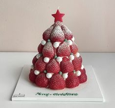 a christmas tree made out of strawberries on top of a white surface with a red star