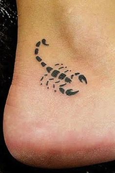 a small scorpion tattoo on the side of a person's foot, with black ink