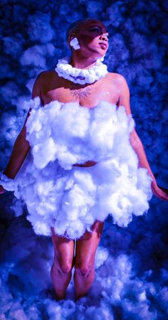 a woman in a cloud costume is walking through the clouds with her hands on her hips