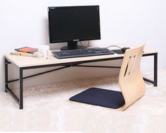 a computer desk with a chair next to it and a monitor on top of it