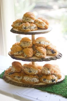 three tiered trays filled with pastries sitting on top of a green mat