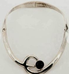 Estate Alicia de la Paz Taxco Minimalist Necklace is Fine Mexican Silver at is best!  Weighing nearly Four Ounces of 950 SILVER, this Vintage Choker features a Bezel Set Obsidian Cabochon and  makes  a Statement worn with Jeans or that favorite Black Dress.  950 Silver is more valuable than Sterling Silver as it is 95% pure as opposed to Sterling, which is 92.5% pure. Brand: Alicia de la Paz Style: Minimalist  Materials: Mexican Fine Silver Necklace Length: 15.00" Necklace Closure Type: Box Tab Contemporary Formal Jewelry With Polished Finish, Contemporary Polished Jewelry For Formal Occasions, Contemporary Polished Formal Jewelry, Contemporary Formal Necklaces With Polished Finish, Minimalist Formal Necklace With Tension Setting, Contemporary Formal Necklace With Polished Finish, Contemporary Polished Necklace For Formal Occasions, Contemporary Polished Finish Necklace For Formal Occasions, Adjustable Tension Setting Jewelry For Formal Occasions