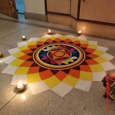 a colorful carpet with candles on it in the middle of a floor that looks like a flower