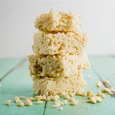 a stack of rice krispy treats sitting on top of a green table next to white beans