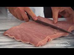 a person cutting meat with a large knife