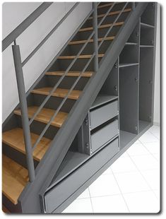 a metal stair case with drawers underneath it