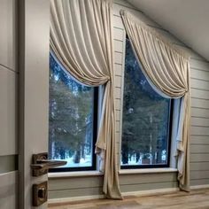 an open window with drapes on it in a room that has wood floors and white walls