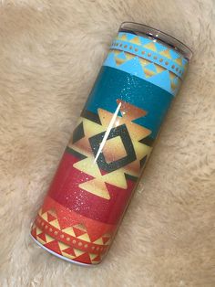 a colorful can with a clock on it sitting on a white fur covered floor next to a rug