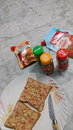 two pieces of bread sitting on top of a paper plate next to condiments